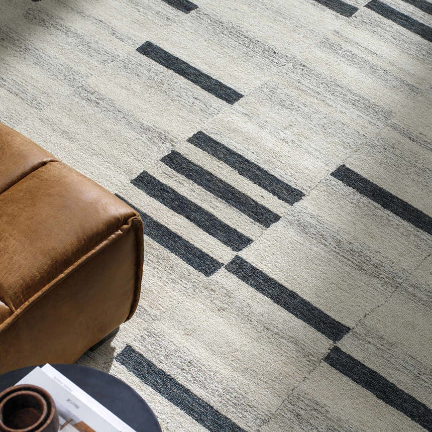 Close-up of the Aibonito rug: beige wool with a bold, geometric black stripe pattern. Modern style. Styleshot