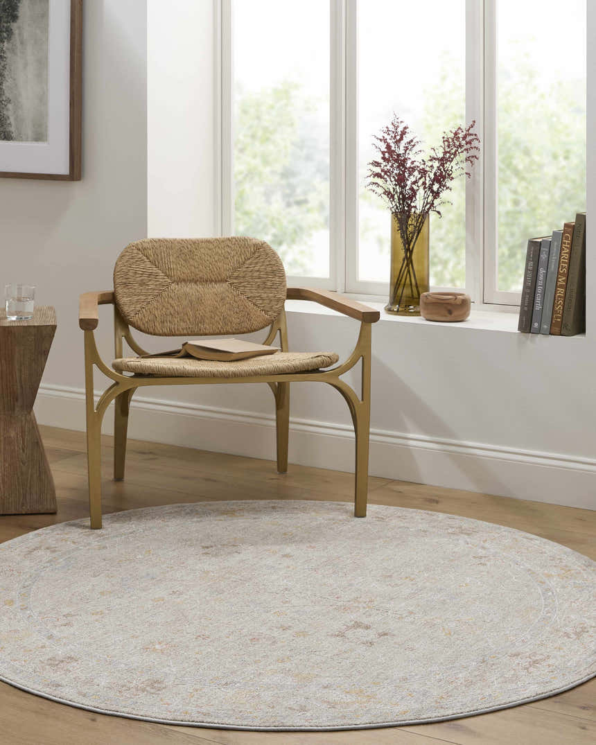 Light-filled room with a round Amina Oushak rug, woven chair, wood accents, and neutral tones for a cozy, farmhouse-style space. Roomscene-Round