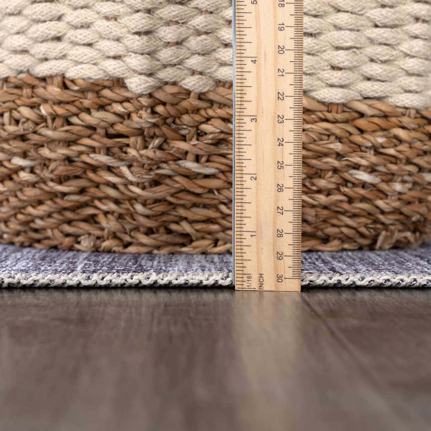 Close-up of the Barny Gray Blue Washable Rug showing texture and thickness with a ruler for scale. Pile