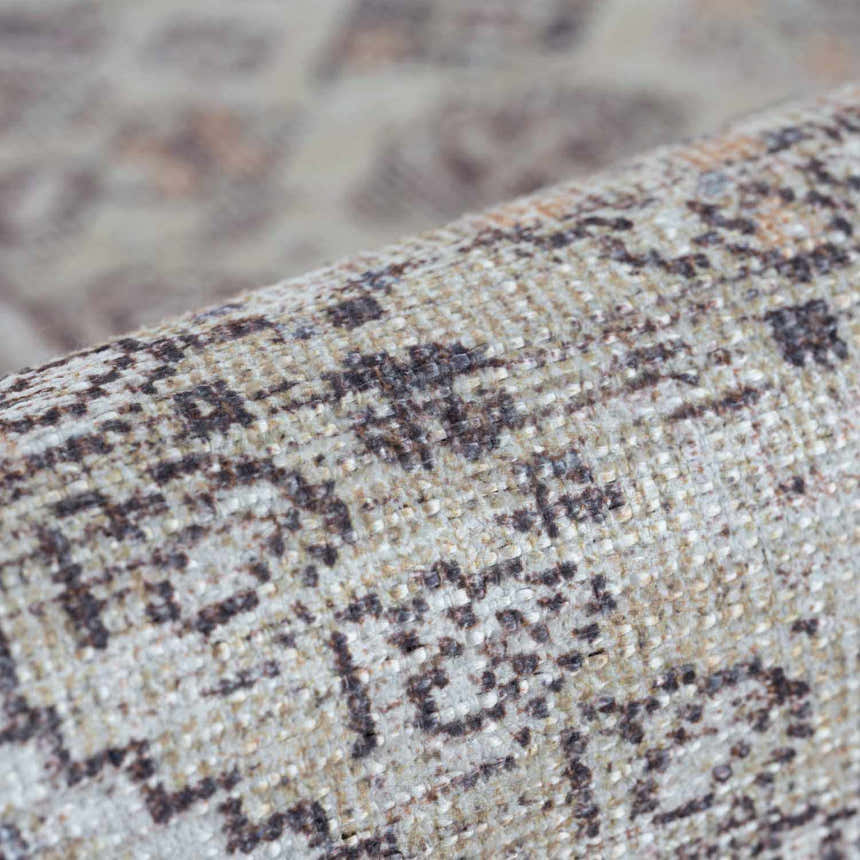 Close-up of the Barny Tan Washable Area Rug showing its woven texture and traditional black and tan pattern. Fold