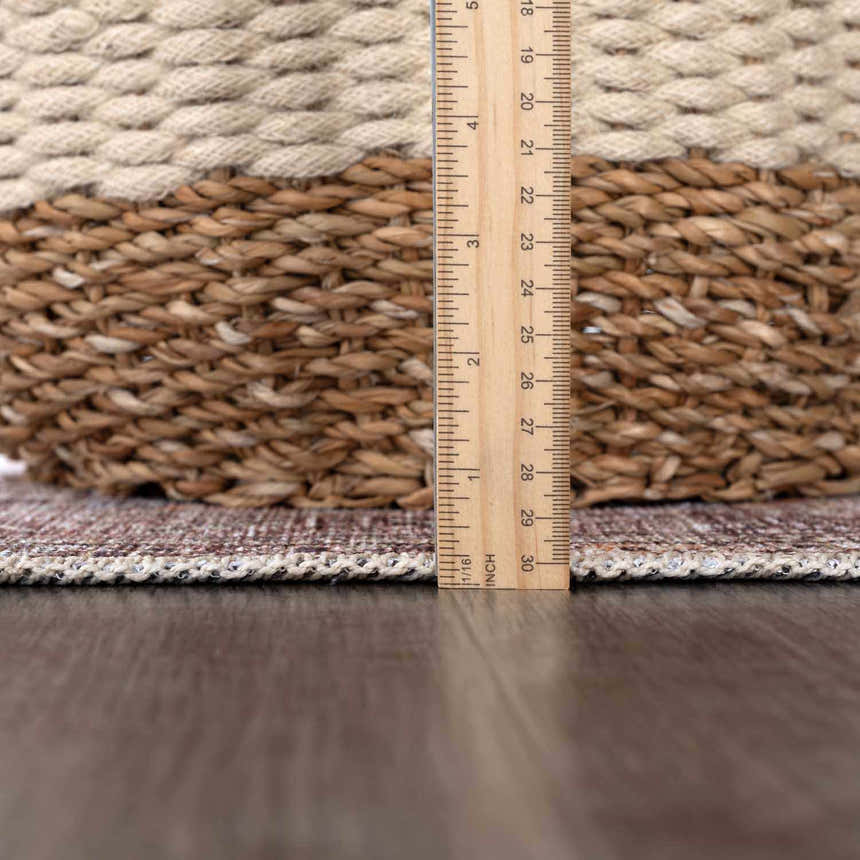Close-up of Barny Tan Washable Area Rug showing rug thickness with a ruler. Tan, brown, and ivory tones. Pile