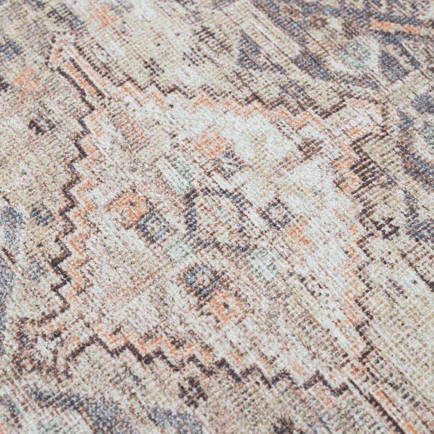Close-up of the Barny Tan Washable Area Rug, featuring a traditional design in tan, orange, gray, and ivory hues. Texture