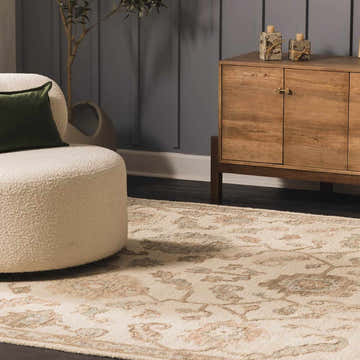 Living room scene with a Callum Oushak rug, cream boucle chair, wood cabinet, and gray walls. Farmhouse style. Roomscene-Rectangle