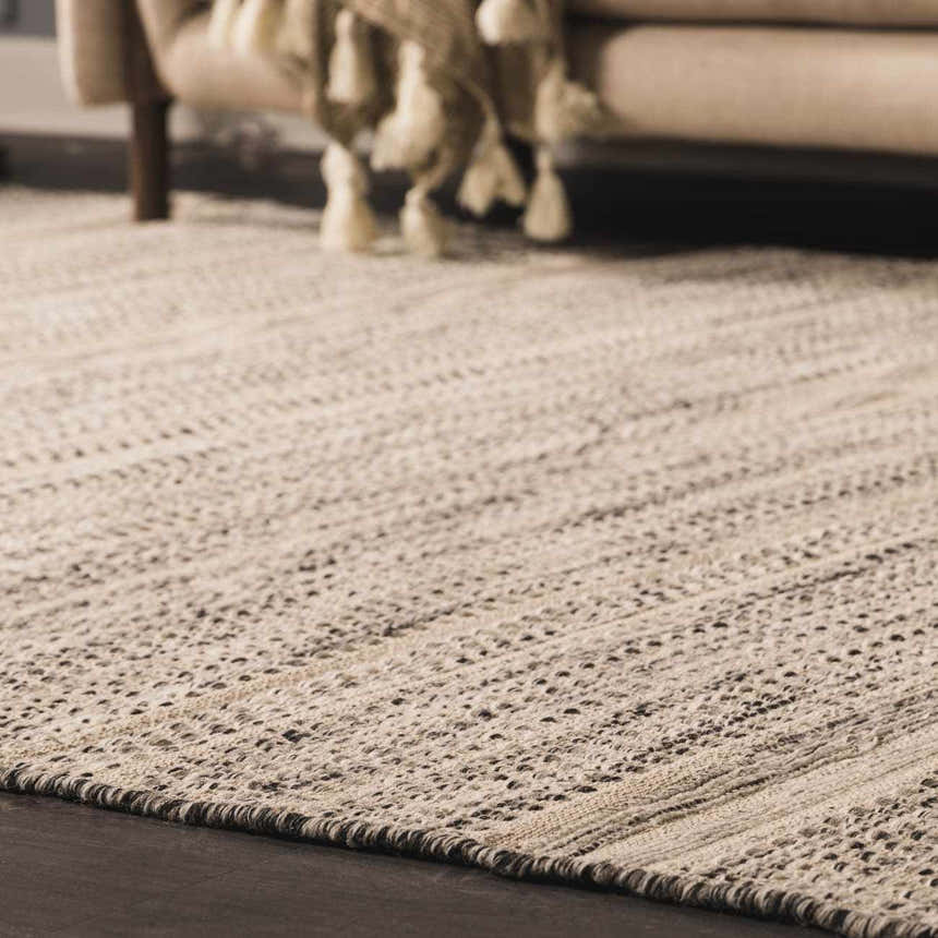 Close-up of the hand-woven Arabi Wool Area Rug in light beige and gray, with a subtle textured pattern. Roomscene-Rectangle