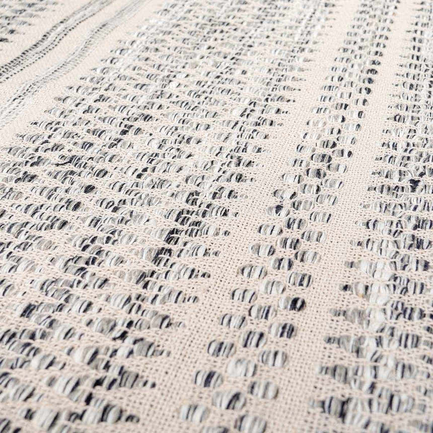 Close-up of the hand woven Arabi Wool Area Rug. Black, gray, and light beige create a textured, transitional design. Texture