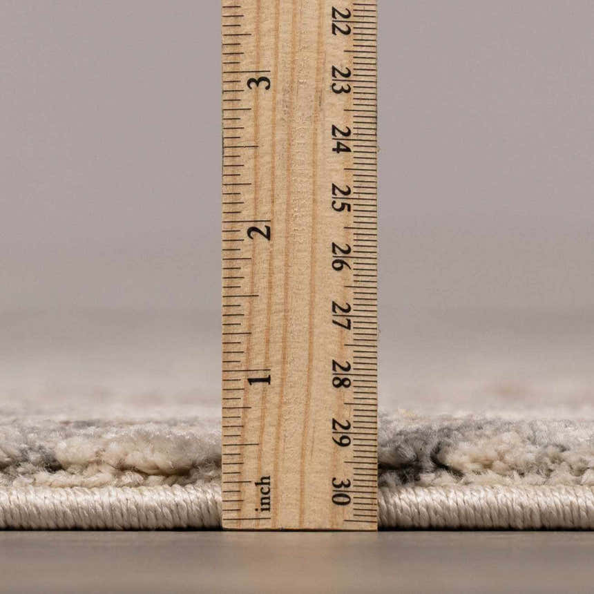 Close-up of the Vaeda Blue & Beige Thick Luxe Rug showing its plush pile height with a ruler for scale. Pile
