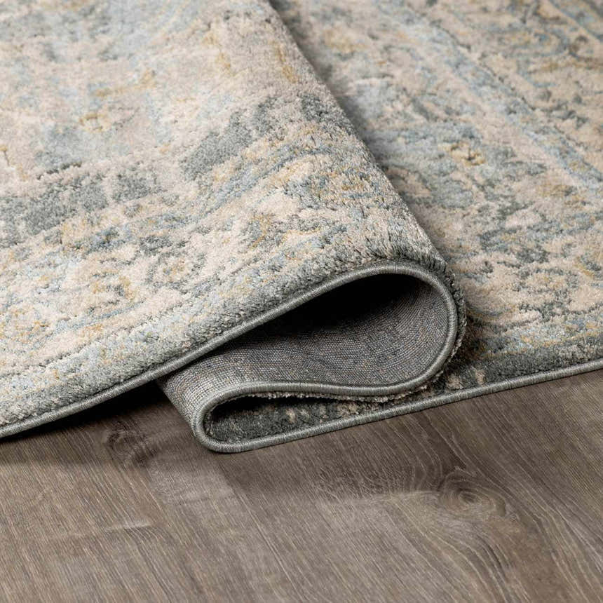 Close-up of the Vaeda Blue Thick Luxe Rug showing its beige, gray, and blue traditional pattern and soft texture. Fold