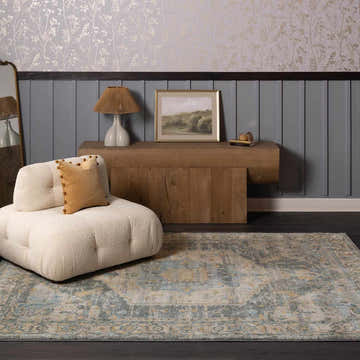 Living room scene with a Vaeda Blue rug, cream chair, wood console table, and gray paneled wall. Roomscene-Rectangle