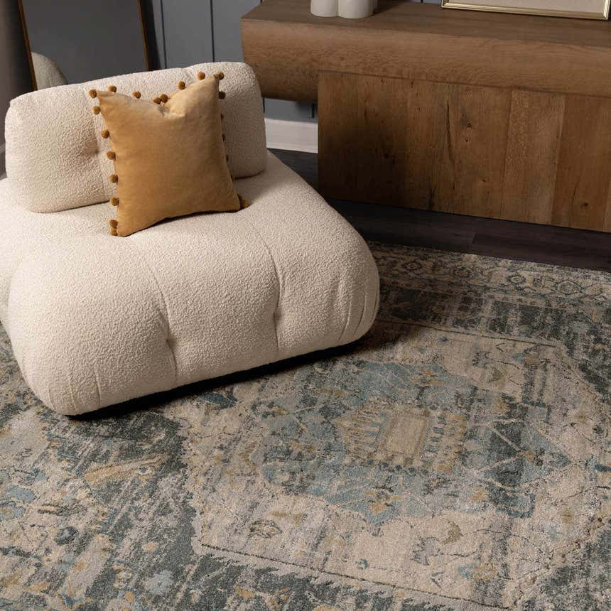 Living room scene with a beige chair on the Vaeda Blue Thick Luxe Rug in beige, gray, and teal. Styleshot