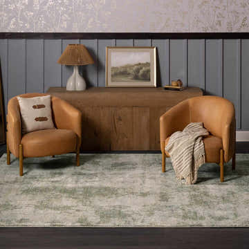 Living room scene with two leather chairs on a beige and olive Zazie Thick Luxe Rug. Roomscene-Rectangle