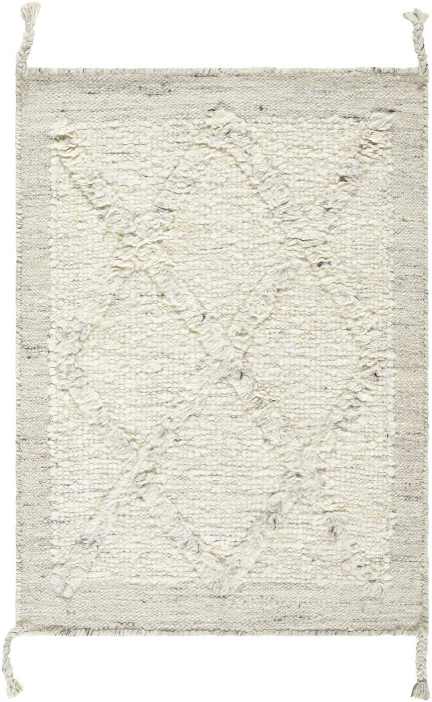 Close-up of the Awen rug. Hand-knotted wool rug in beige, charcoal, cream, and gray with a subtle geometric pattern and braided tassels. Design-Rectangle-23