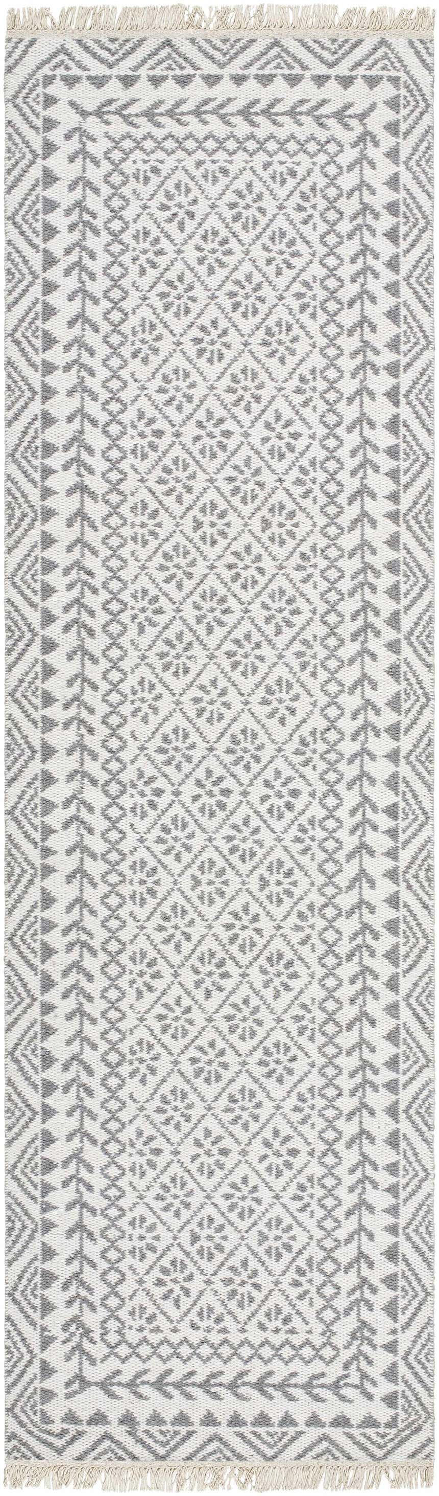 Close-up of the hand woven Bayou Area Rug. Features a gray and beige farmhouse-style geometric pattern and tasseled edges. Design-Runner-268