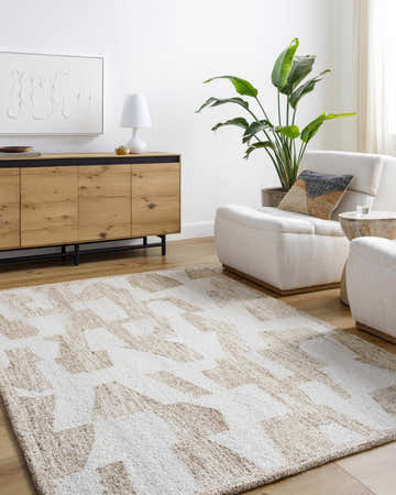 Living room scene with Brendy Beige Area Rug, ivory chairs, and wooden cabinet against a white wall. Roomscene-Rectangle