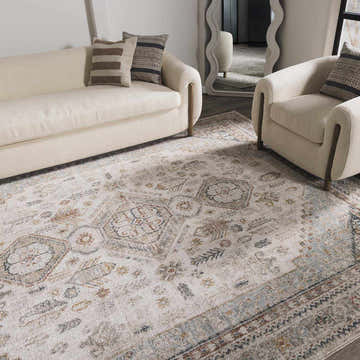 Living room scene with a Kouta Cream Area Rug, beige sofa and chair, and neutral decor. Roomscene-Rectangle