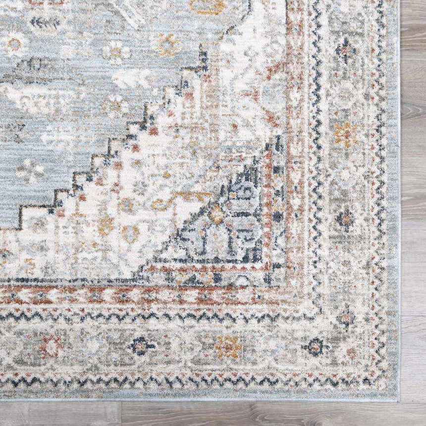 Close-up of the Kouta Gray Blue Area Rug. Features traditional patterns in beachhouse blue, beige, charcoal, and mustard tones. Swatch