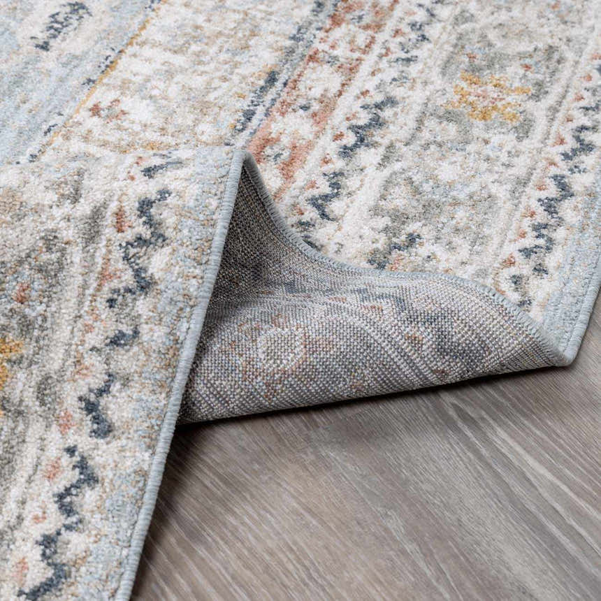 Close-up of the Kouta Gray Blue Area Rug showing its traditional pattern, soft texture, and durable machine-woven construction. Fold