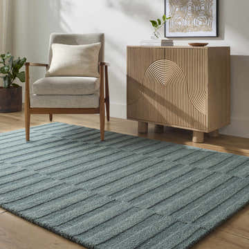Living room scene with Idaho Broken-Striped Petrol Blue Area Rug, gray chair, and wood cabinet. Contemporary style. Roomscene-Rectangle