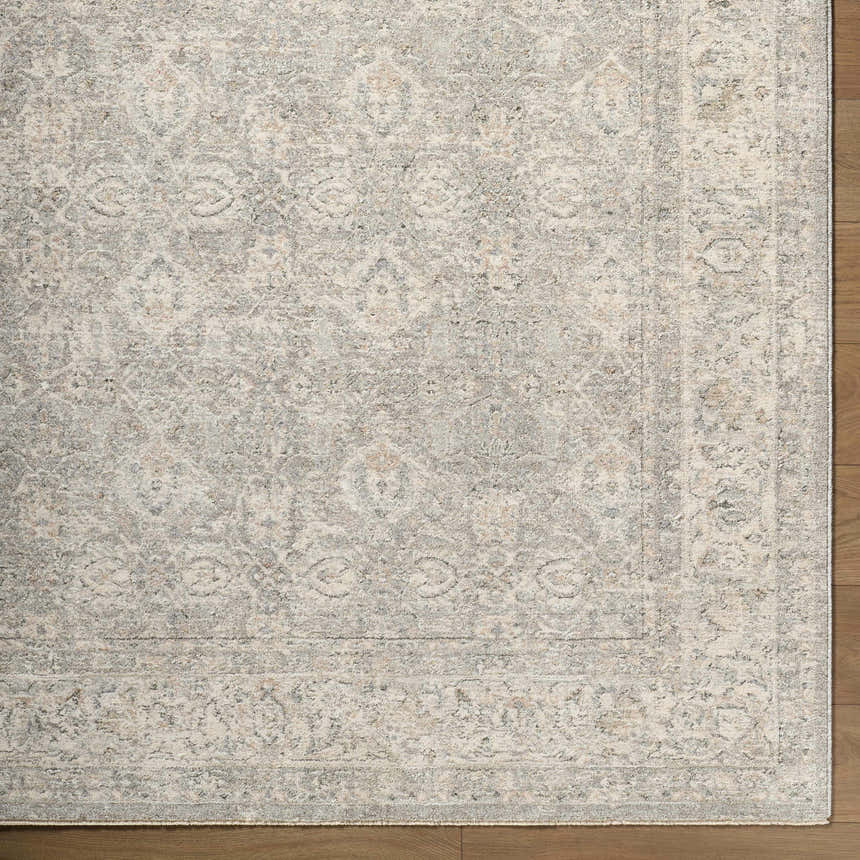 Close-up of the cream Buddug Area Rug showing a traditional, farmhouse pattern with sage and slate blue accents. Corner