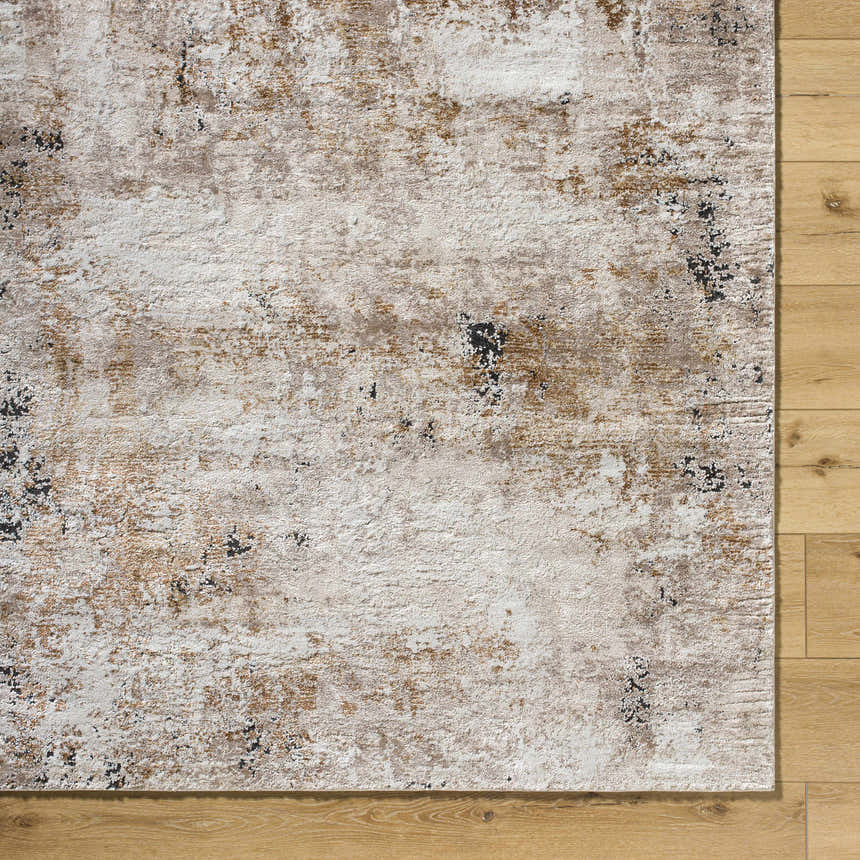 Close-up of Weeko Luxe Area Rug. Contemporary design in ivory, tan, and black on light wood floor. Corner