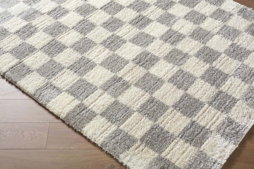 Close up of Belita Tan Luxe Shag Area Rug showing cream and light gray checkered pattern and soft, plush texture. Corner