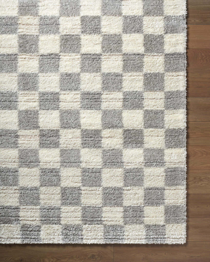 Close-up of the Belita Tan Luxe Shag Area Rug featuring a cream and light gray checkerboard pattern and a shag texture. Corner