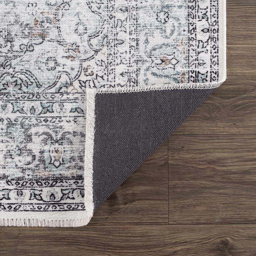 Close-up of the Light Blue Holi-4603 Washable Area Rug showing its traditional vintage pattern and charcoal backing. Fold