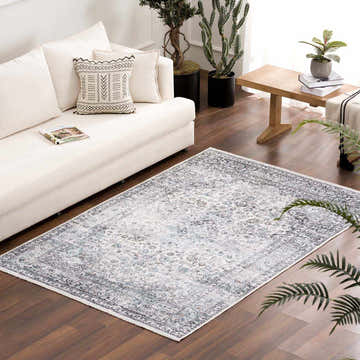 Living room scene with a Light Blue Holi-4603 washable rug, white sofa, wood floors, and houseplants. Roomscene-Rectangle