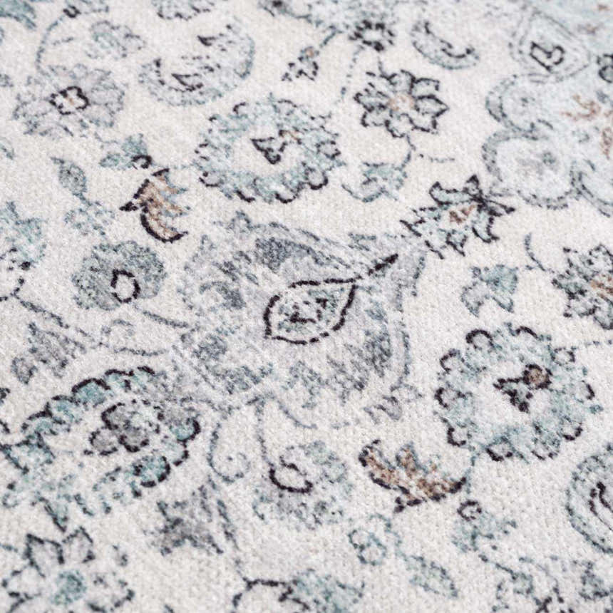 Close-up of the Light Blue Holi-4603 Washable Area Rug. Features a traditional floral pattern in light blue, gray, and brown tones. Texture