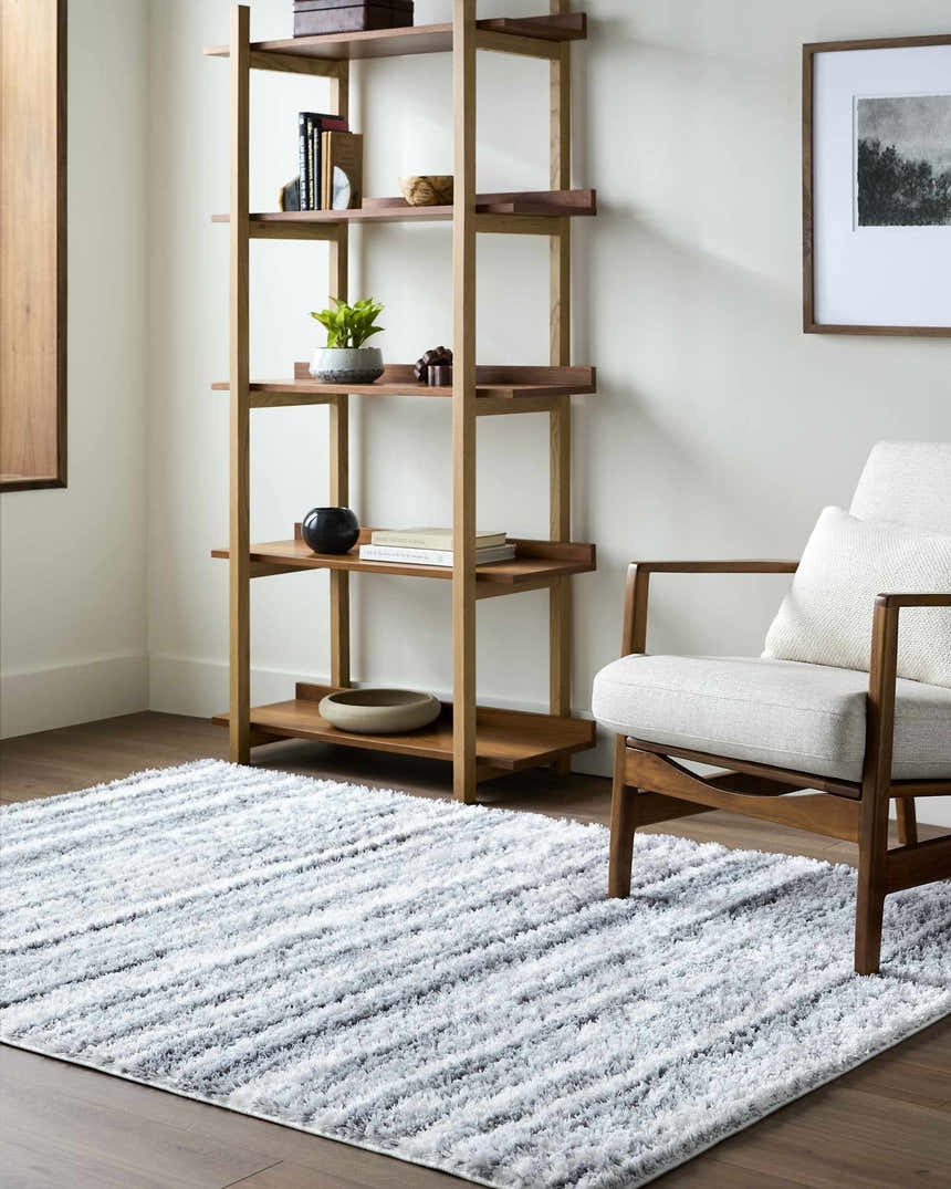 Living room scene with a cream chair and Blaise Area Rug in cream and gray. Contemporary style. Roomscene-Rectangle
