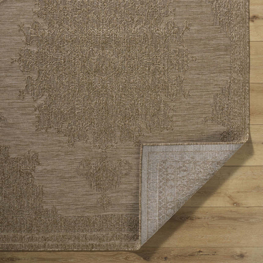Close-up of the beige Bahula Area Rug showing its traditional floral pattern and machine-woven texture. Fold