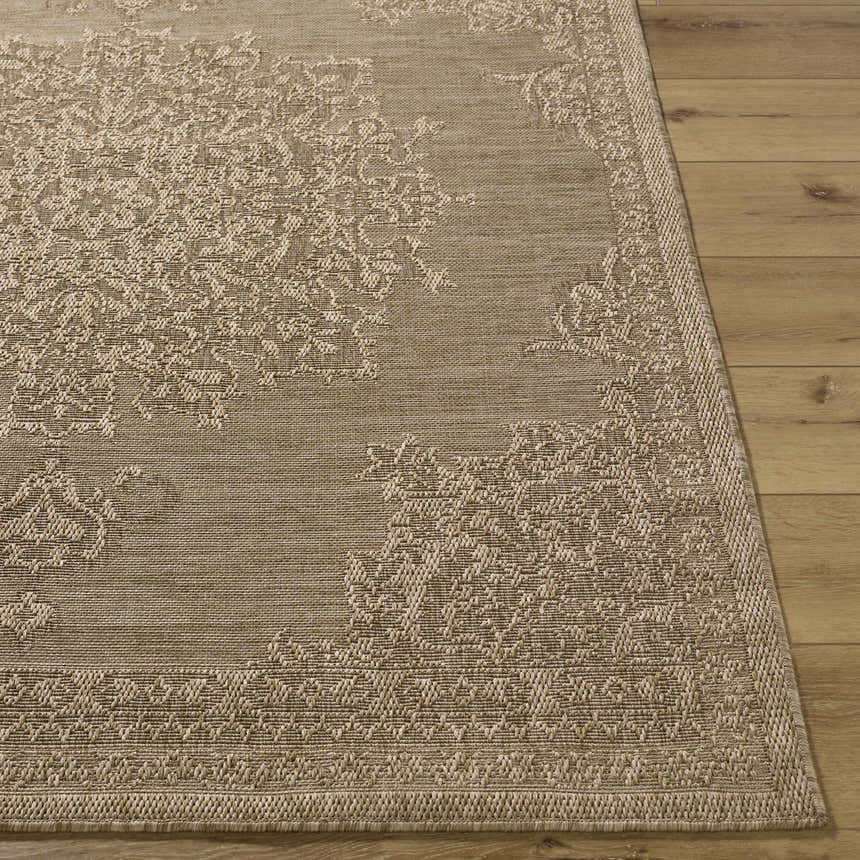 Close-up of the beige Bahula Area Rug showing its traditional, machine-woven pattern and texture on a light wood floor. Front