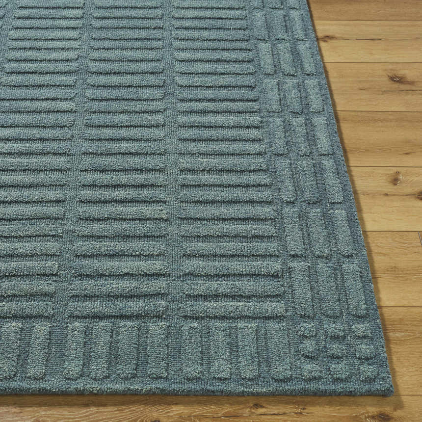 Close-up of the hand-tufted Birger Slate Blue Area Rug. Features a contemporary geometric design and 100% wool texture. Front