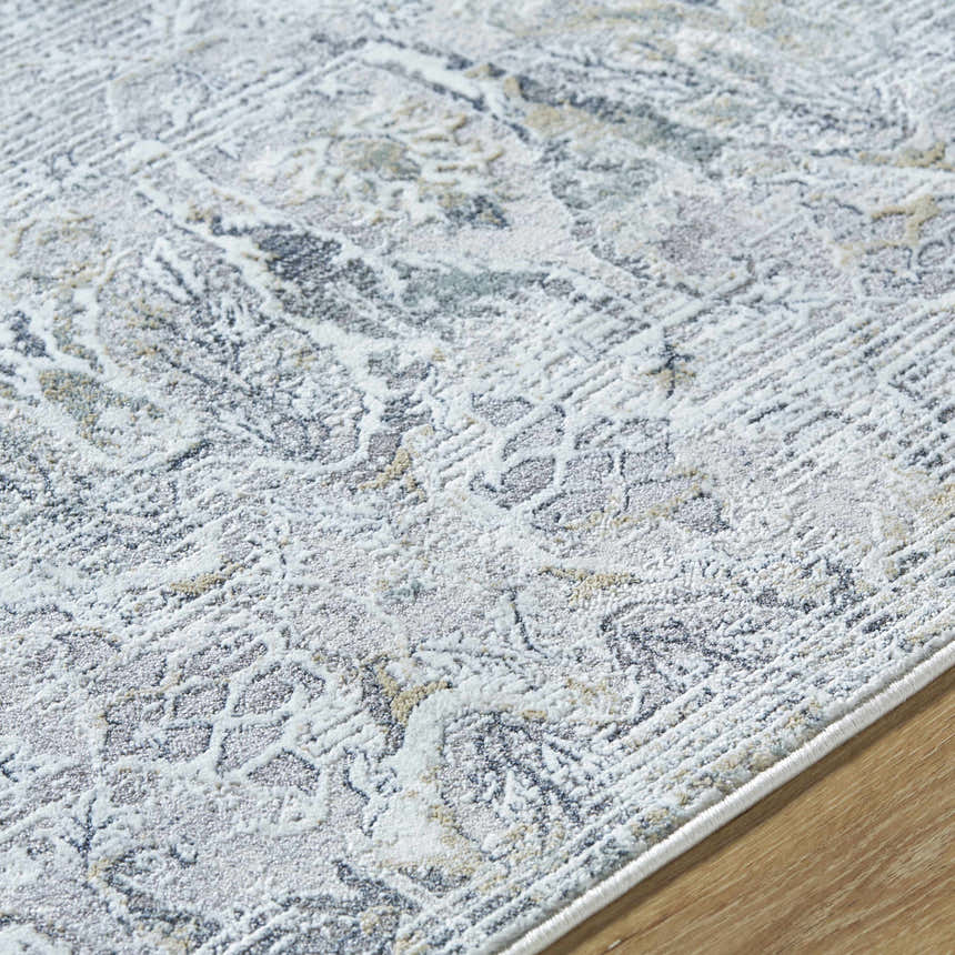 Close-up of the Bryony Area Rug. Farmhouse style rug in light silver, silver gray, and slate blue with traditional pattern. Texture