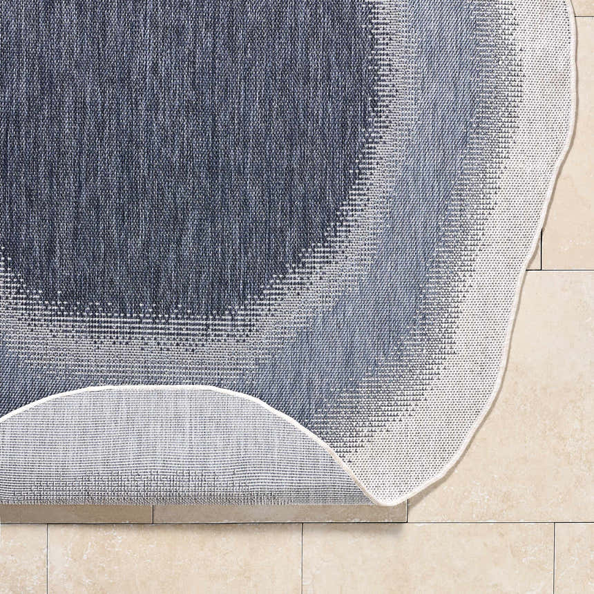 Close-up of the machine-woven Burian Blue Area Rug showing its blue, cream, and navy farmhouse-style pattern and texture. Fold