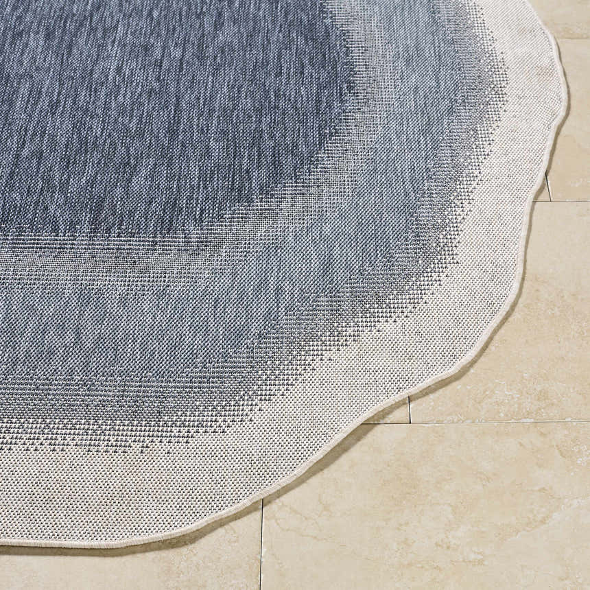 Close-up of the woven texture and wavy edge of the Burian Blue Area Rug in blue, cream, and navy. Front