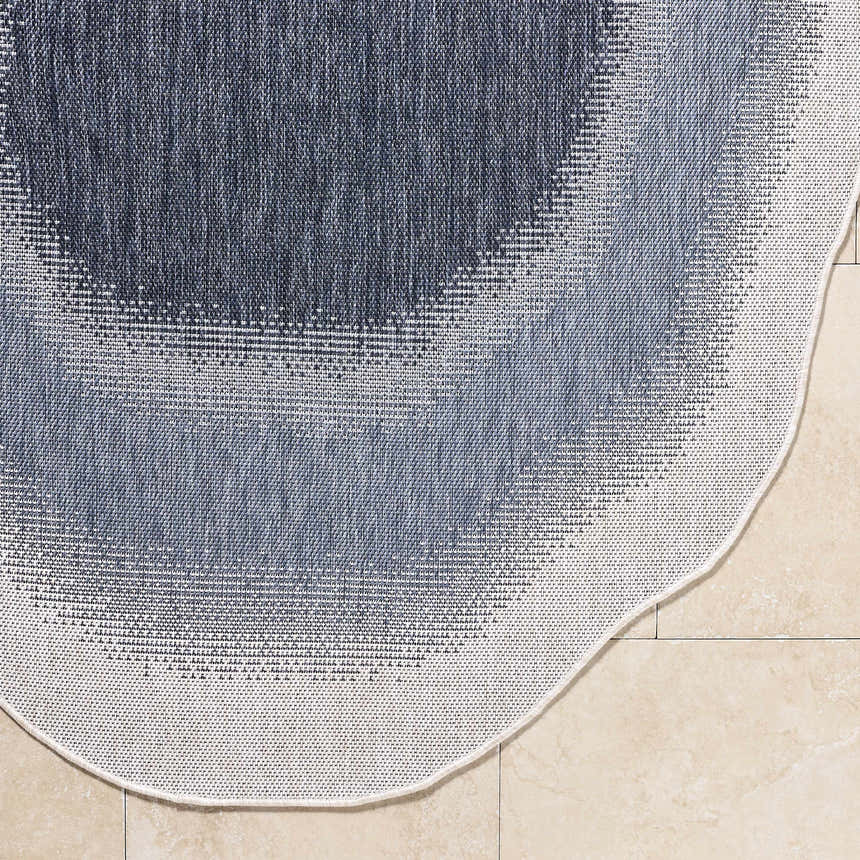 Close-up of the machine woven Burian Blue Area Rug showing blue, cream, and navy hues and polypropylene texture. Corner