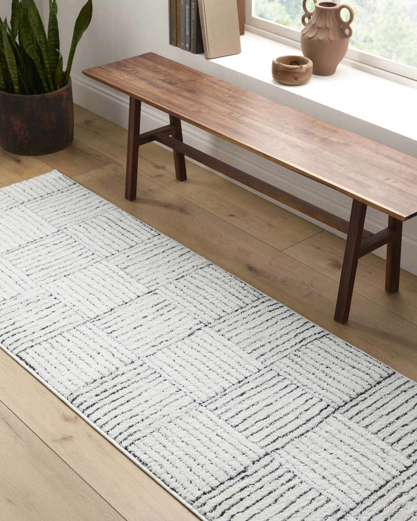 Entryway with a Modern Scandi Architect I Area Rug, wood bench, and plant. Ivory and black rug. Roomscene-Runner