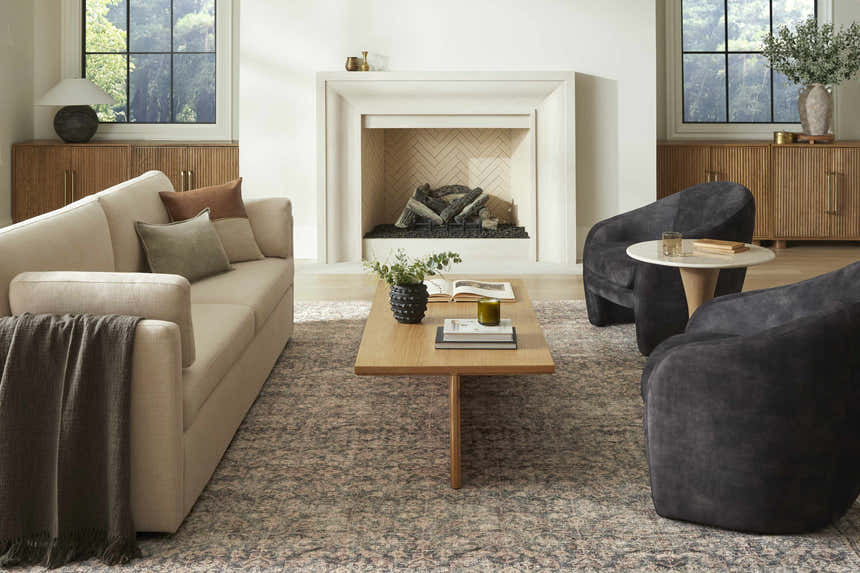 Living room scene with beige sofa, fireplace, and Collins Avenue III Vintage Damask Area Rug in beige, red, and green. Roomscene-Rectangle