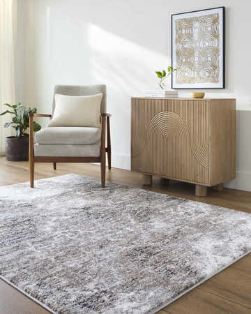 Living room scene with a gray chair, wood cabinet, and the Britta Area Rug in black, ivory, and gray. Roomscene-Rectangle