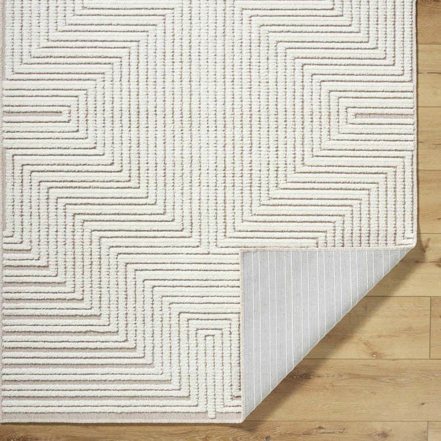 Close-up of the Briana Beige Washable Area Rug showing its geometric pattern, texture, and non-slip backing. Fold