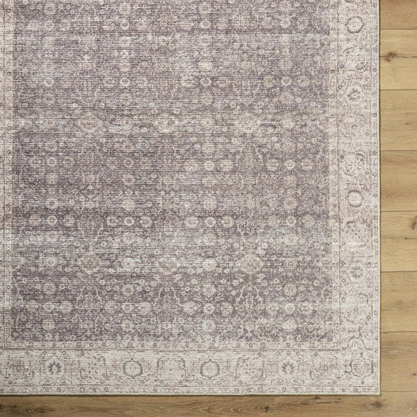 Close-up of the Spokane Dark Brown Area Rug showing its traditional floral pattern and dark brown, cream, and peach colors. Corner