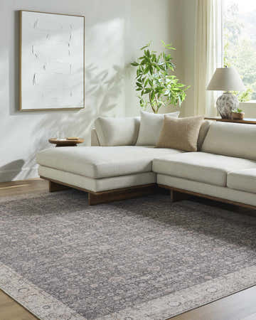 Living room with a neutral sectional sofa and Spokane Maroon Area Rug, a traditional rug in charcoal, ivory, and tan. Roomscene-Rectangle