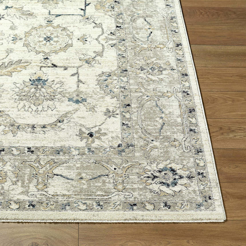 Close up of the Yume Ivory Persian rug showing its charcoal, olive, and slate blue floral pattern and soft texture. Front
