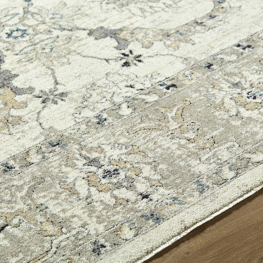 Close-up of the Yume Ivory Persian rug, showing its charcoal, olive, and slate blue floral pattern and soft polyester texture. Texture