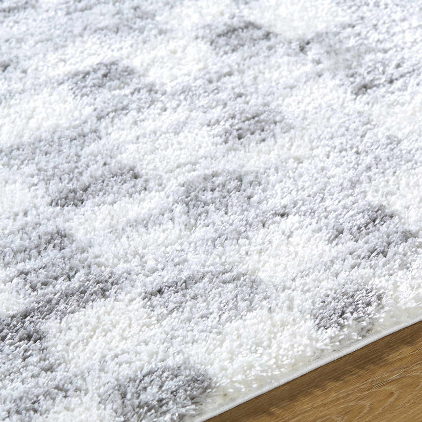 Close-up of the Aneska Area Rug, a gray and ivory shag rug with a geometric pattern and soft, plush texture. Texture