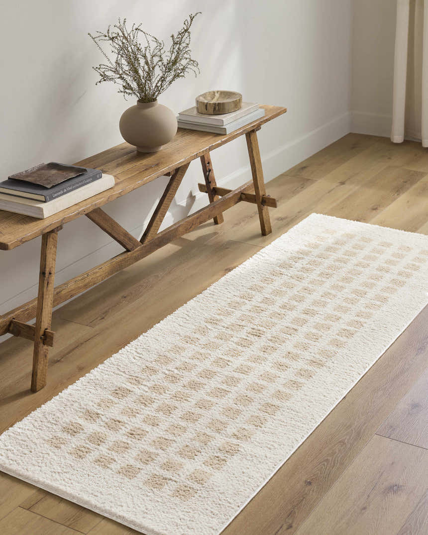 Hallway scene with a Baback Beige Washable Area Rug, wood floors, and a rustic wood bench with books and a vase. Roomscene-Runner