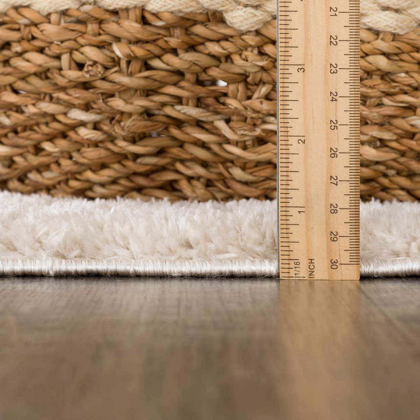 Close-up of the Baback rug pile height with ruler, showing plush texture and woven backing. Pile