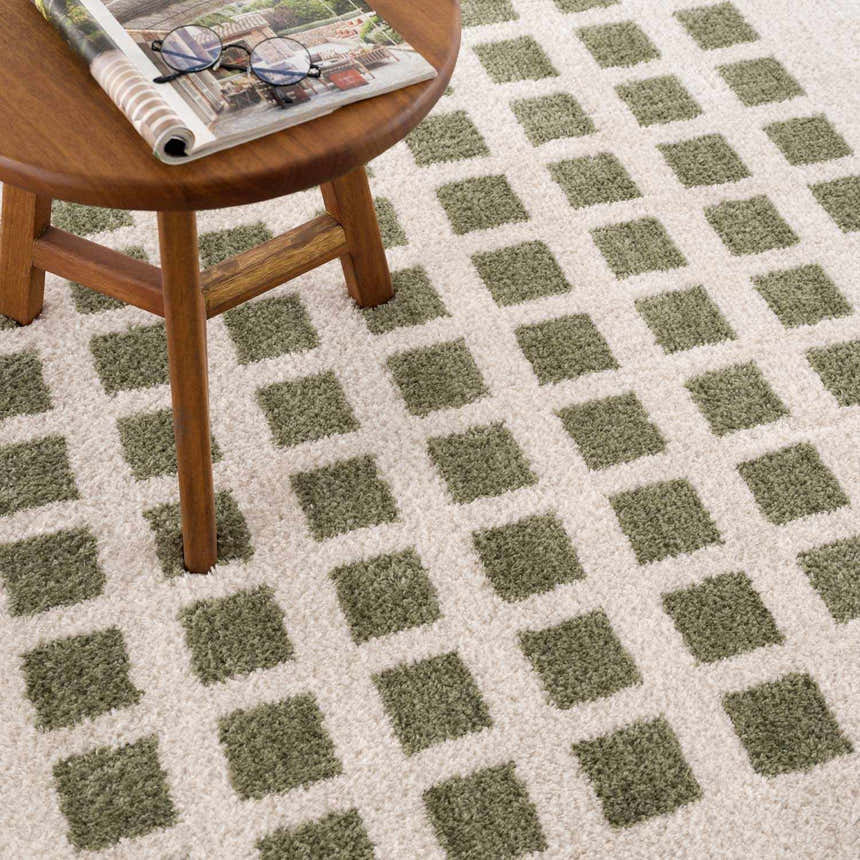 Close-up of the Baback Green Washable Area Rug, featuring a geometric square pattern in lime green and cream. Modern, textured design. Styleshot