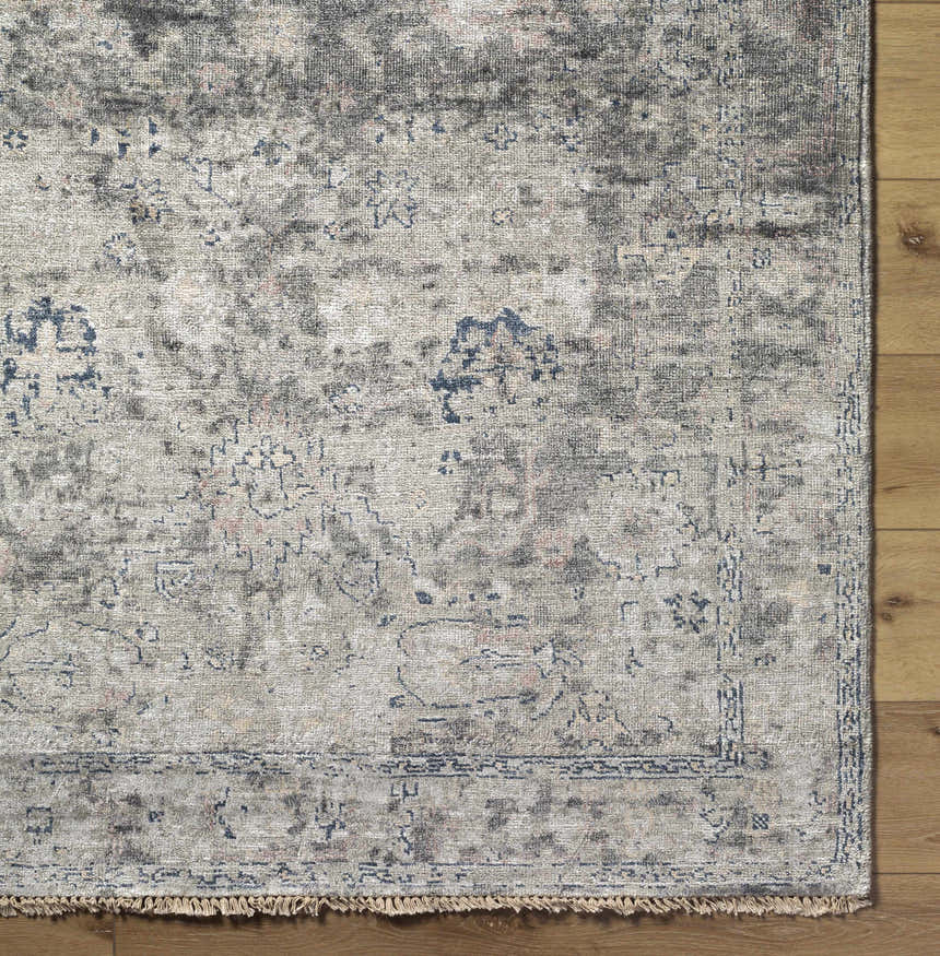 Close-up of the Ballantrae Premium Rug, a hand-knotted viscose rug with beige, charcoal, and blue oriental-inspired patterns. Corner