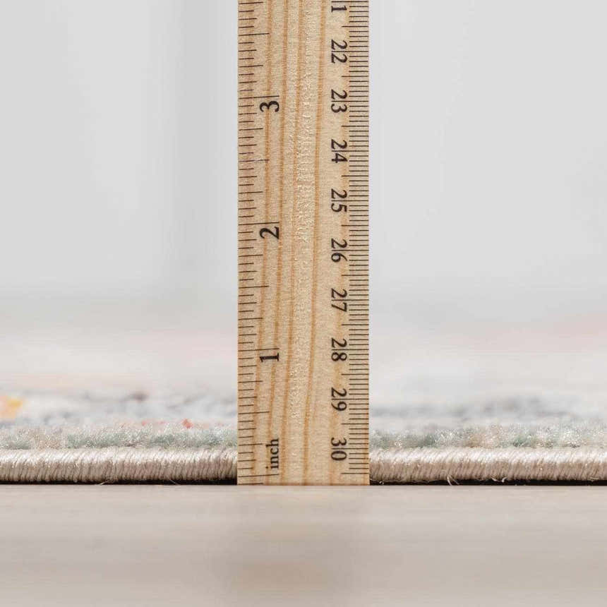 Close-up of the Bolinas Area Rug showing the pile height using a ruler. The rug has a low pile. Pile
